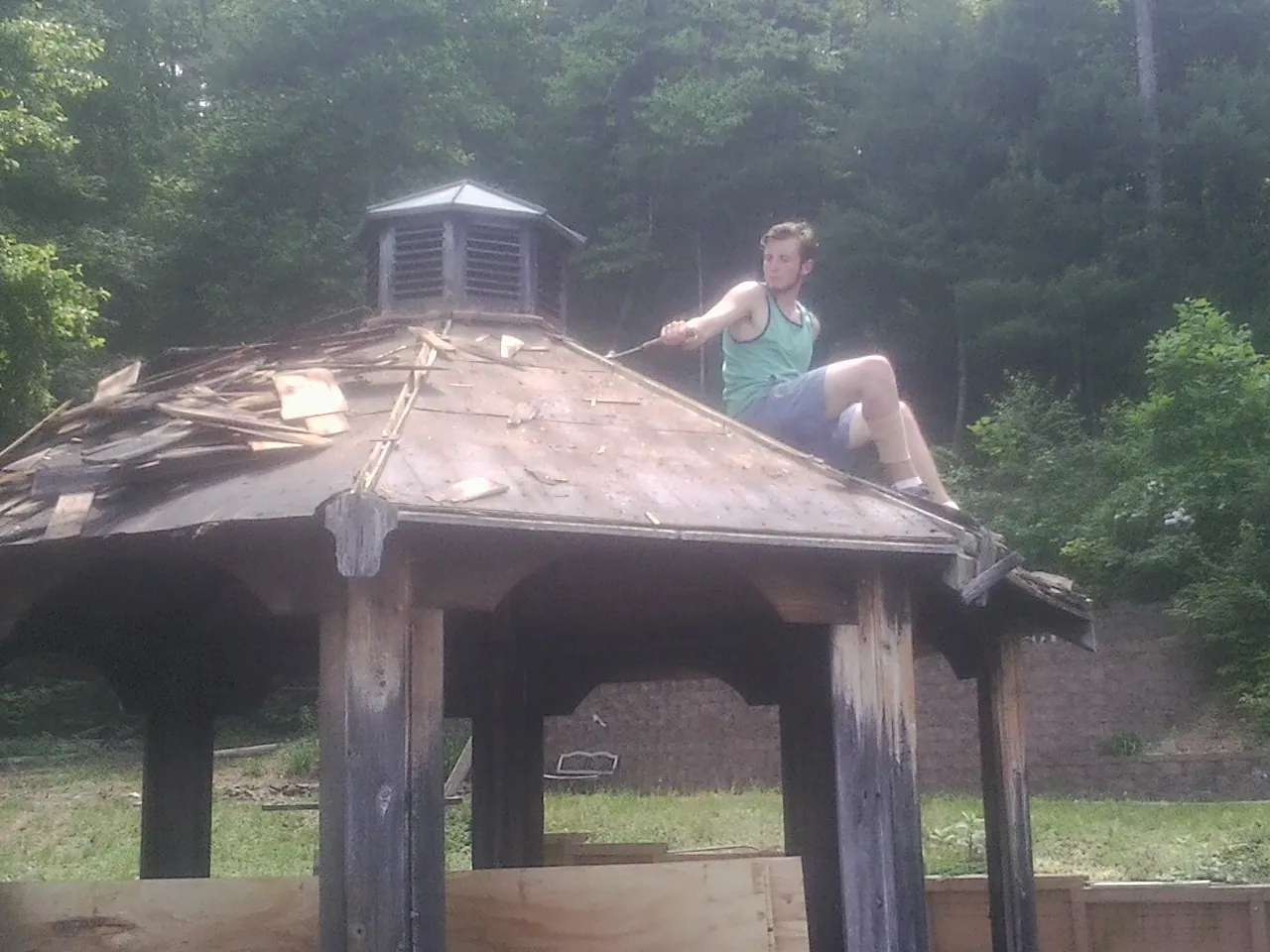 Tearing the old roof off a wooden gazebo before new shakes in Orangeburg
